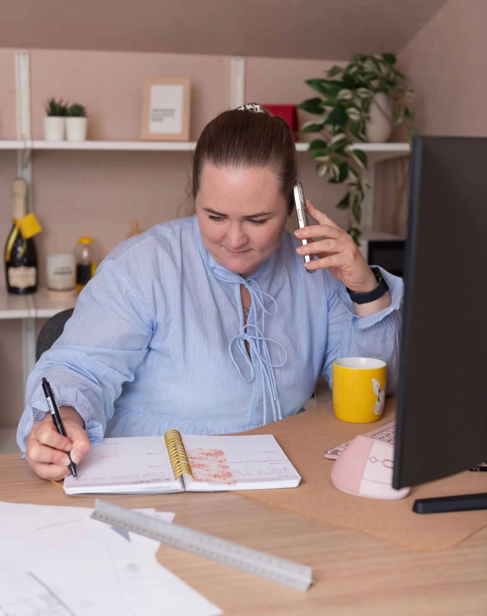 Minnepleie i fokus: Person som skriver i minnebok mens hun snakker i telefonen.